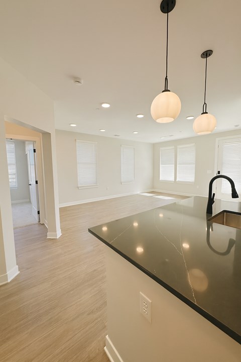 A kitchen with a black counter top and a sink.