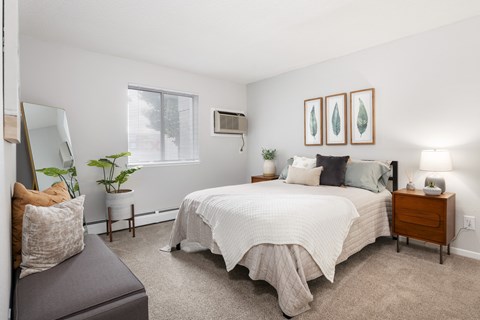 A bedroom with a large bed and a grey couch.