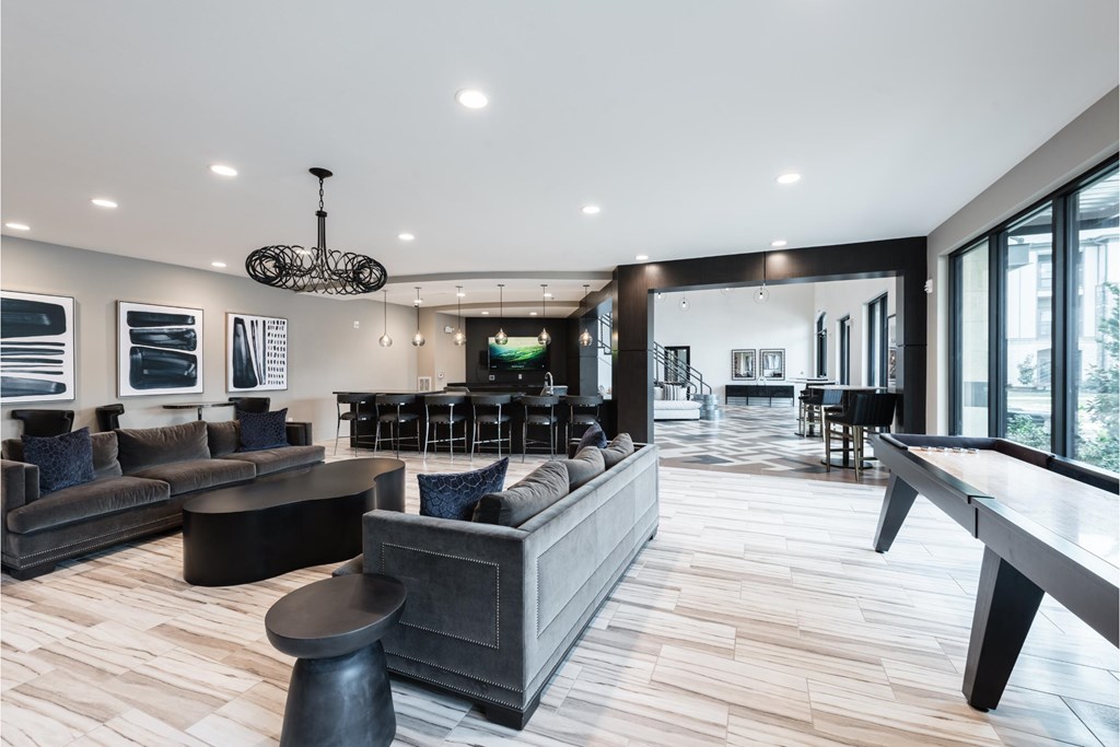 a living room with couches and a bar and a pool table