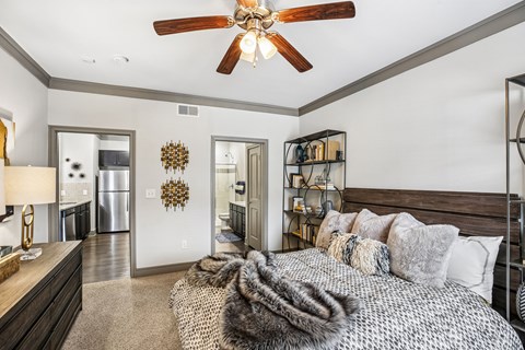 A bedroom with a large bed and a ceiling fan.