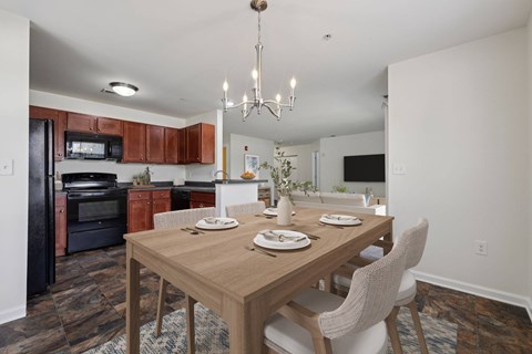 A dining room with a wooden table set for two.