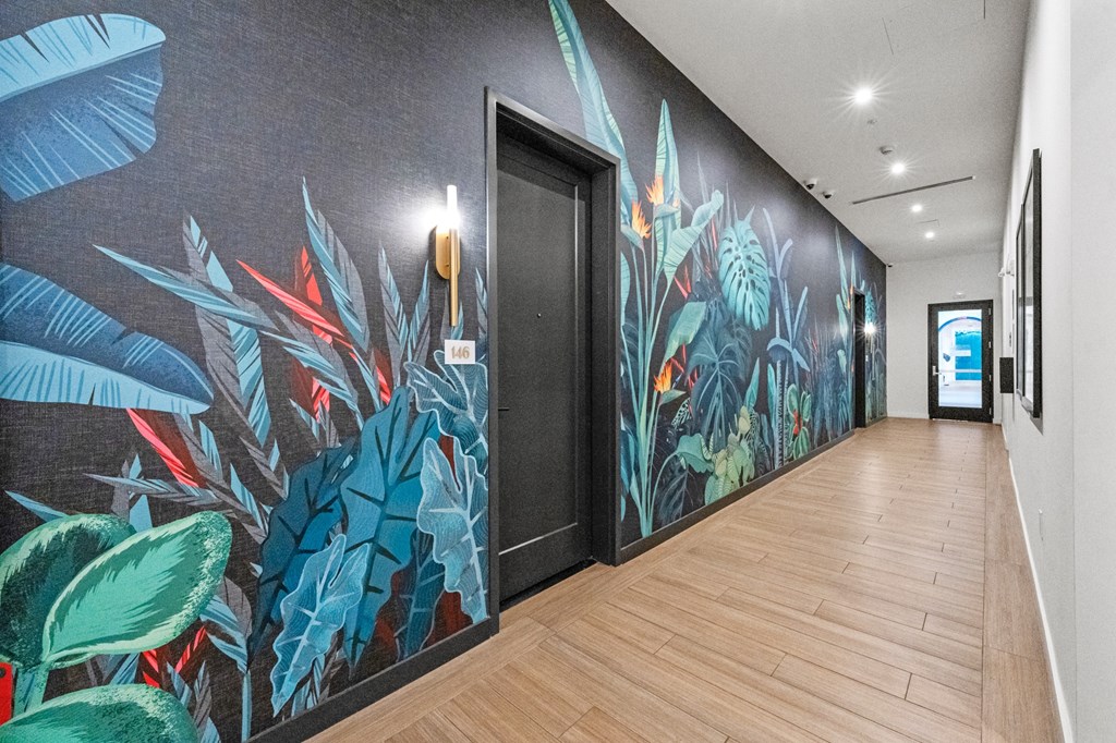 A long hallway with a mural of tropical plants on the wall.