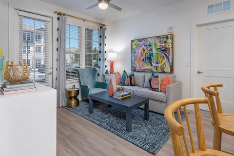 A living room with a couch, chair, and a painting on the wall.