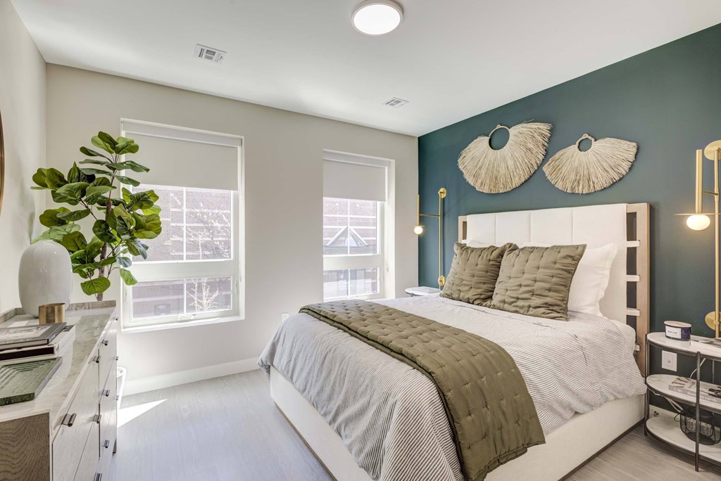 A bedroom with a bed, a nightstand, and a window.