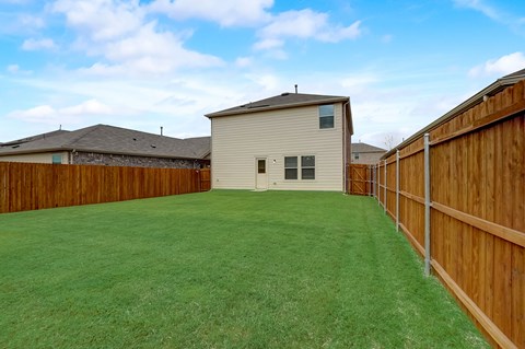 Large backyard,  surrounded by a sturdy wooden fence, creating a well-maintained and private outdoor space