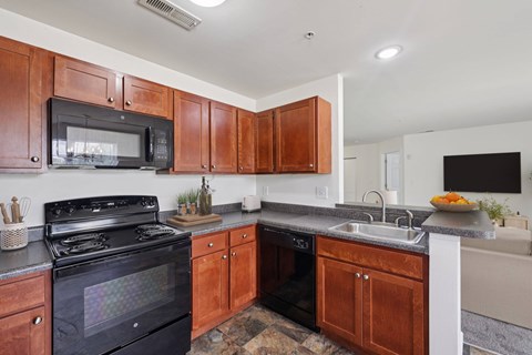 A kitchen with wooden cabinets and a black stove top oven.
