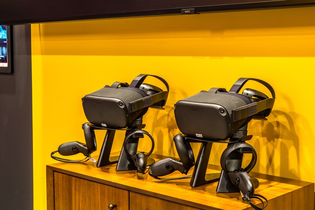 Two VR headsets on a wooden stand.