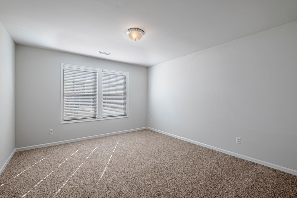an empty room with carpet and a window