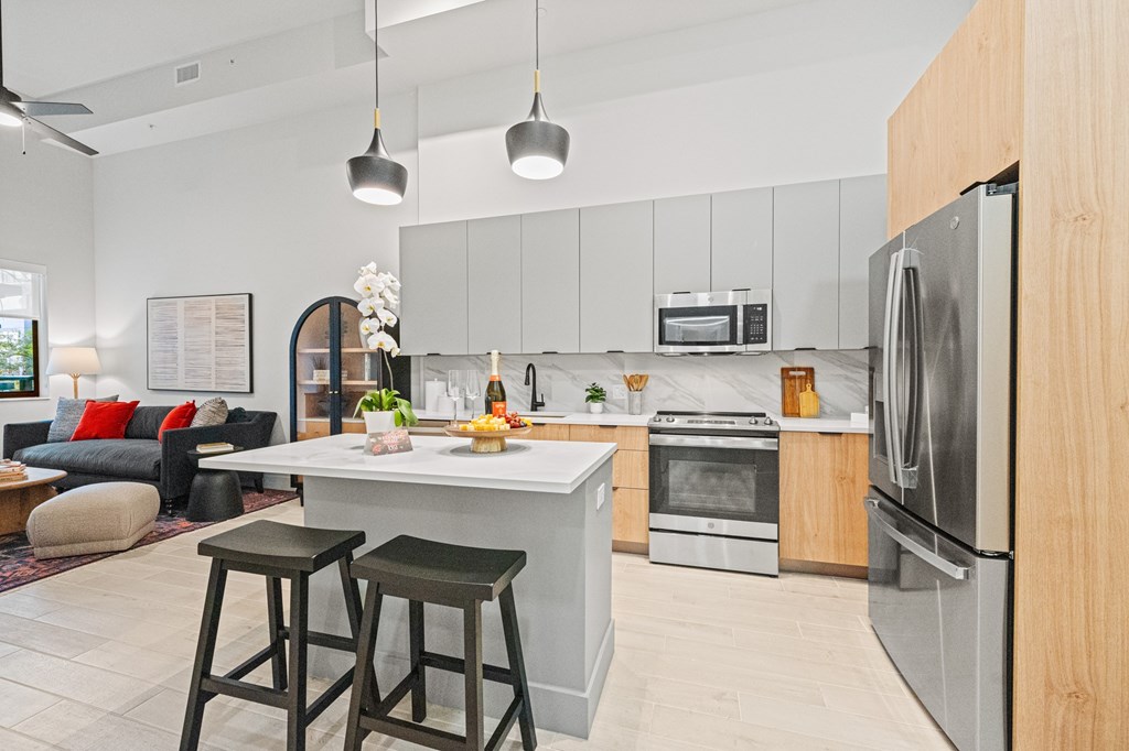 A modern kitchen with a white island and stainless steel appliances.