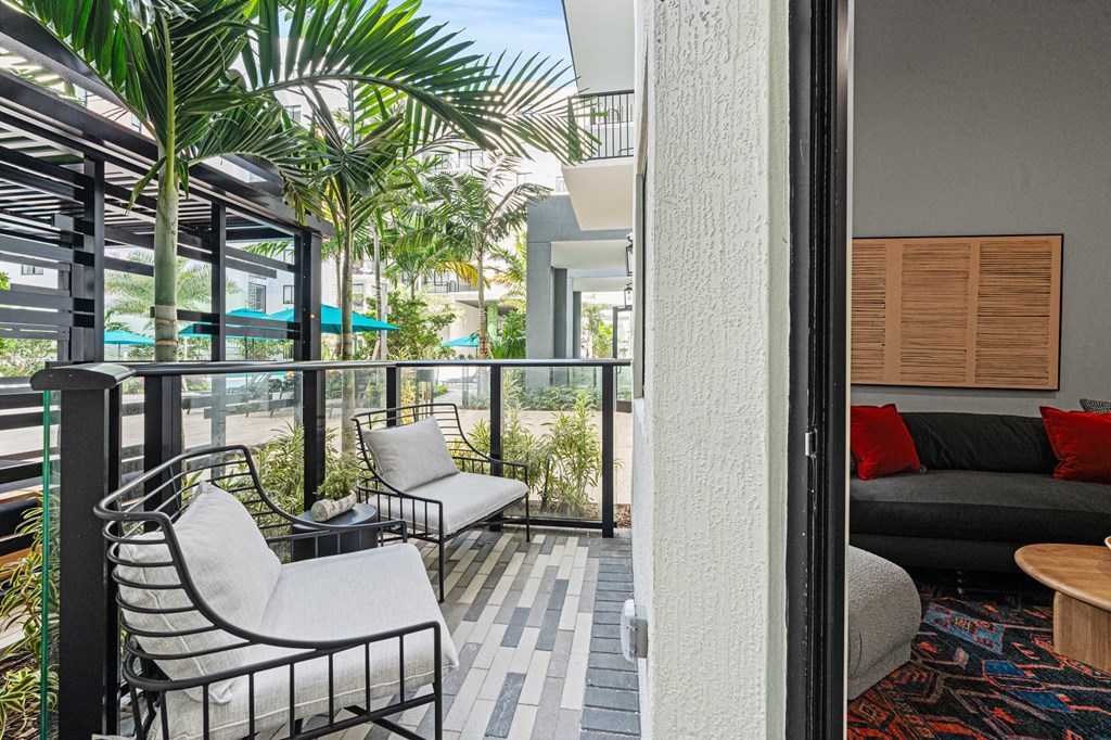 A patio with a table and chairs overlooking a balcony.