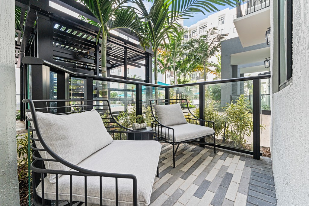 A patio with a white couch and a black metal frame.