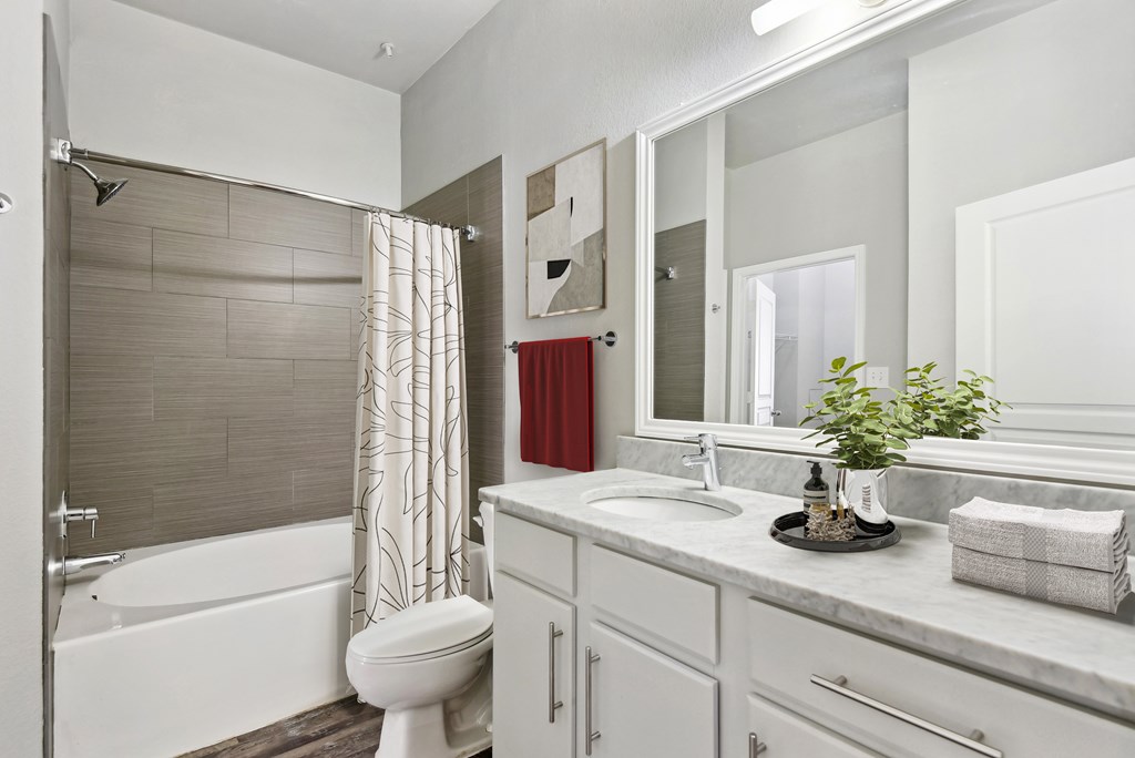 a white bathroom with a shower and a sink and a toilet