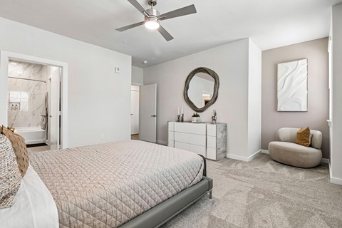 A bedroom with a large bed and a ceiling fan.