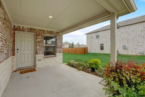 Outdoor Patio with plans surrounding the entrance, large lawn around the home