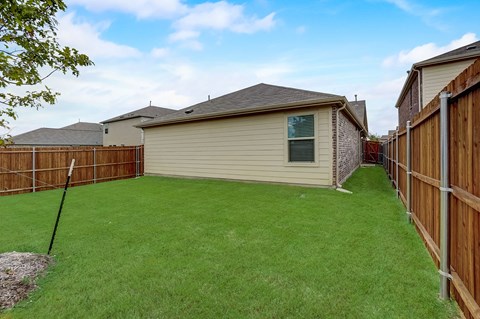 Large backyard,  surrounded by a sturdy wooden fence, creating a well-maintained and private outdoor space