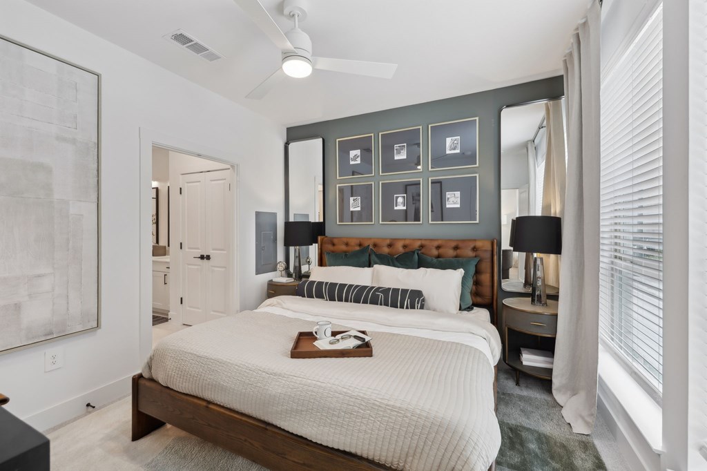 A bedroom with a large bed and a painting on the wall.