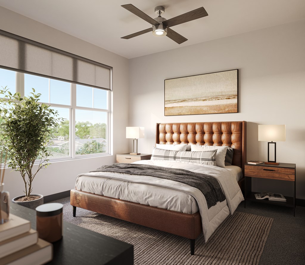 1-Bedroom Luxury Apartments in Westfield, IN - The Union at Grand Junction - Bedroom with Carpeted Flooring, Area Rug, Bed, Nightstands with Lamps, Ceiling Fan, and Large Windows.