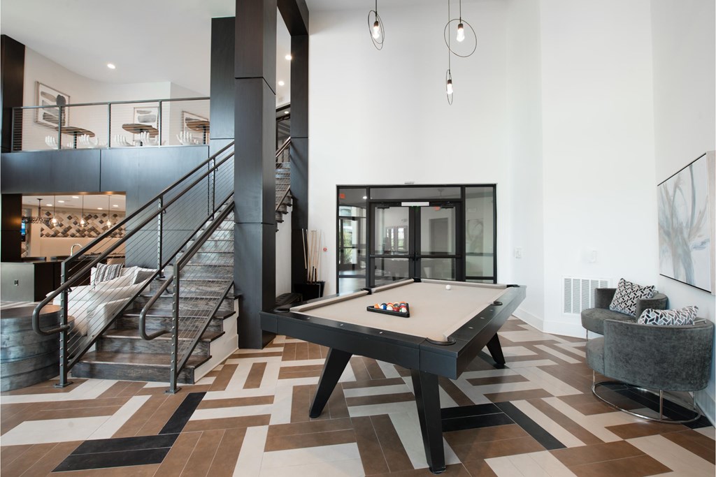 a pool table in a living room with a staircase