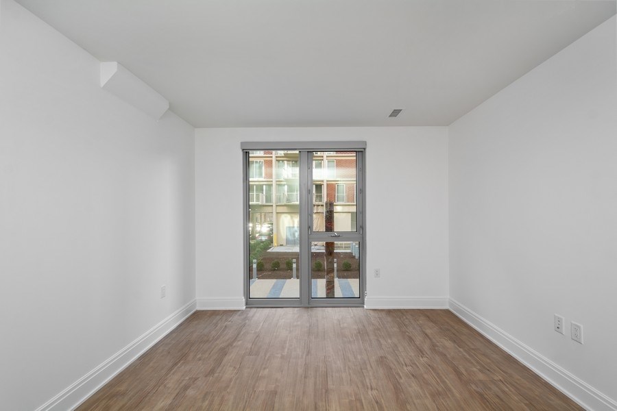 a living room with white walls and a sliding glass door
