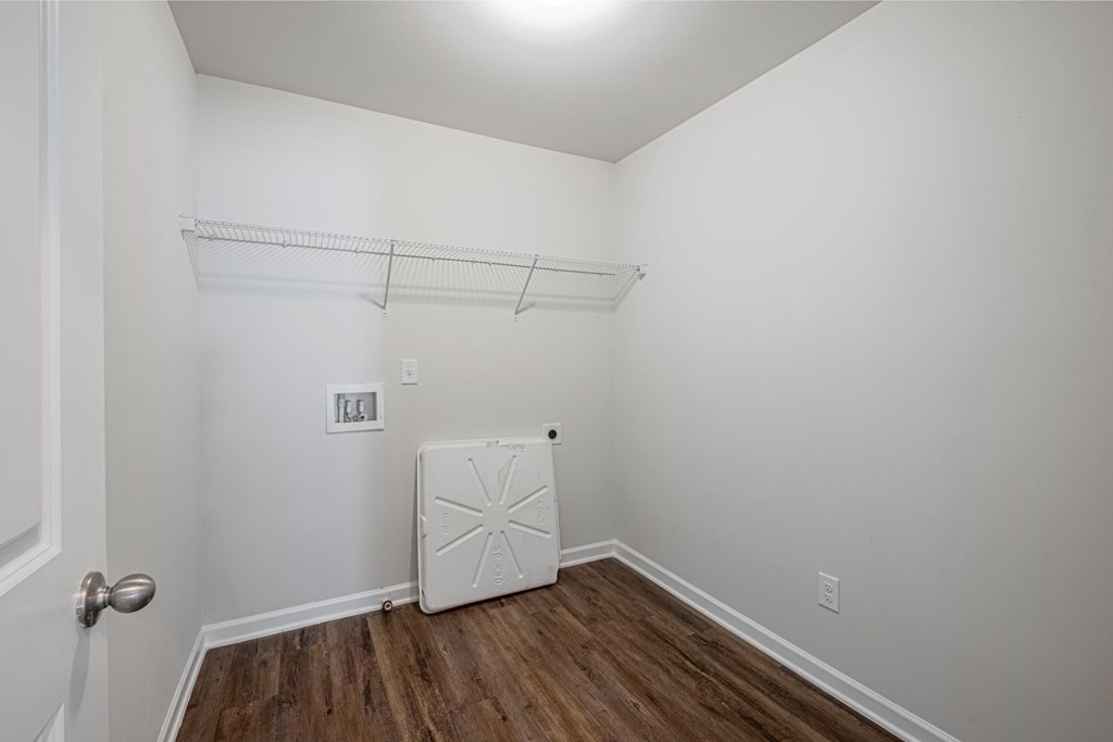 a room with white walls and a white refrigerator in the corner