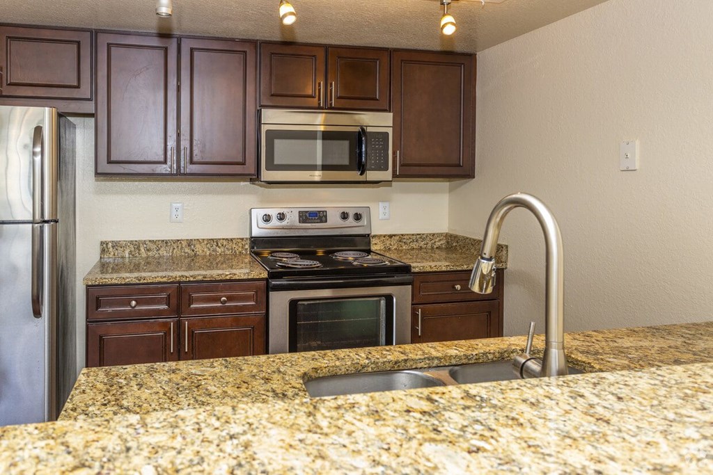 a kitchen with granite counter tops and stainless steel appliances