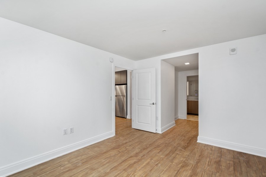 an empty living room with white walls and wood floors
