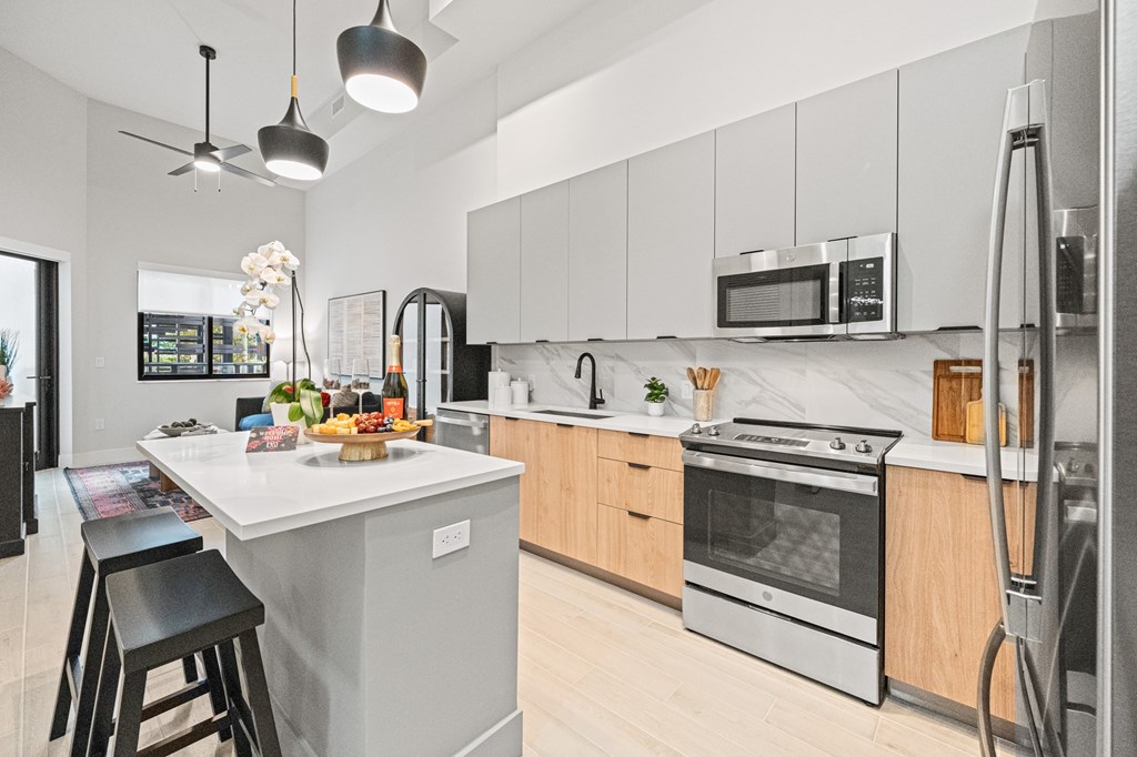A modern kitchen with a white island and stainless steel appliances.