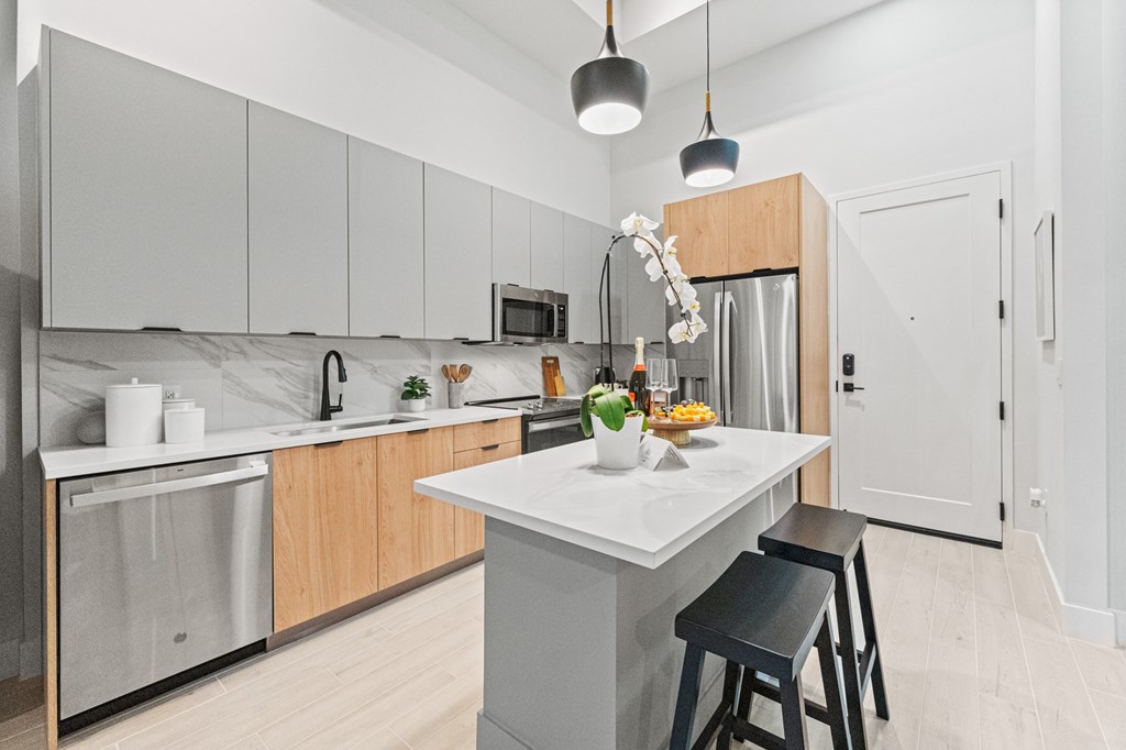 A kitchen with a white counter top and wooden cabinets.
