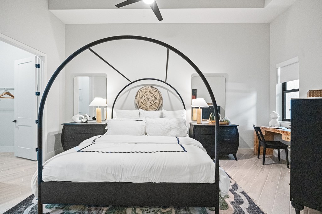 A bedroom with a canopy bed and a dresser with a mirror.