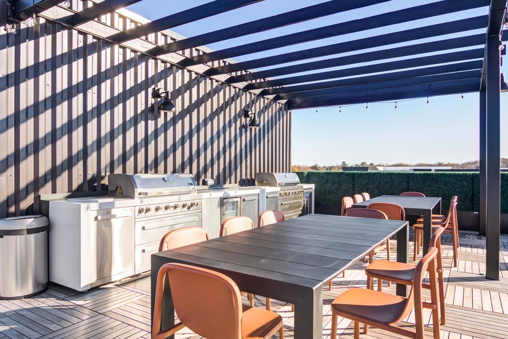 The Beacon rooftop grill and dining area with pergola covering and hanging lights