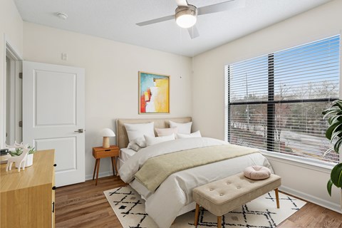 A bedroom with a large bed and a painting on the wall.