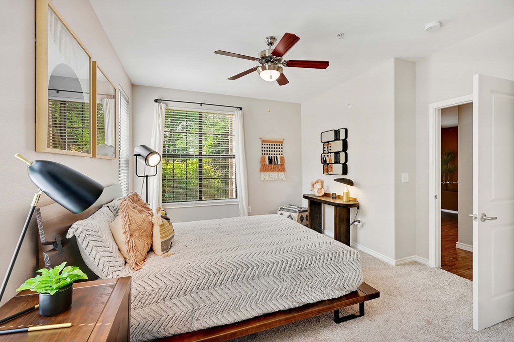 a bedroom with a bed and a ceiling fan