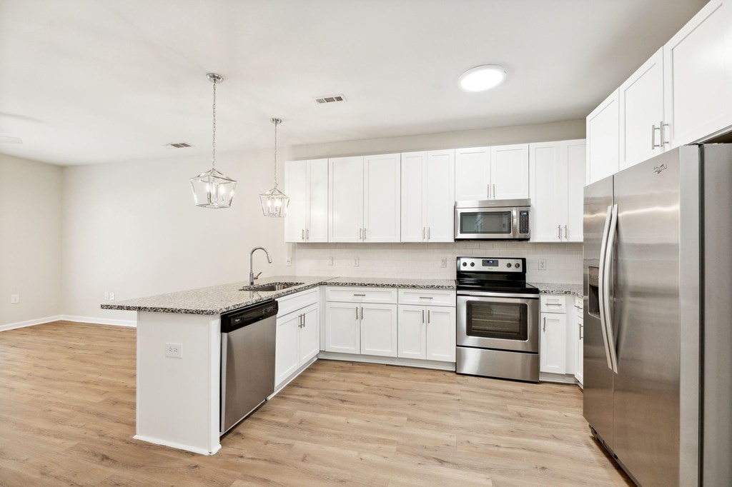 a renovated kitchen with stainless steel appliances and white cabinets