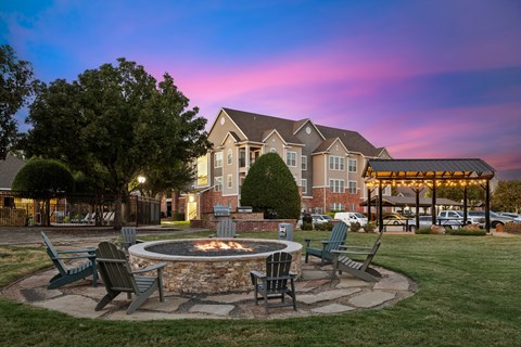 A large house with a fire pit in front of it.