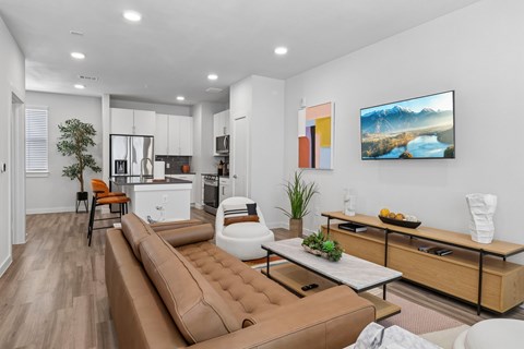A modern living room with a brown leather sofa and a painting on the wall.