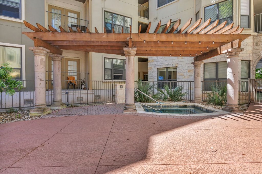 a courtyard with a pool and a building with a pergola