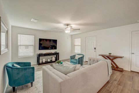 Well-lit living room with hardwood floors and an abundance of natural light