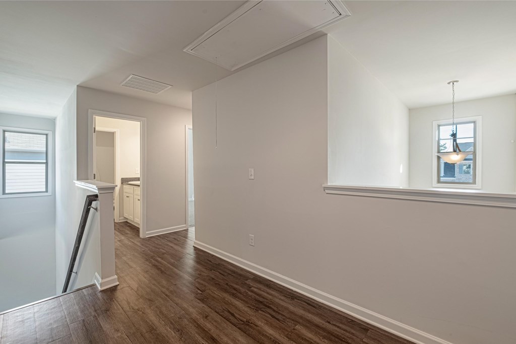 a living room and dining room with white walls and wood floors