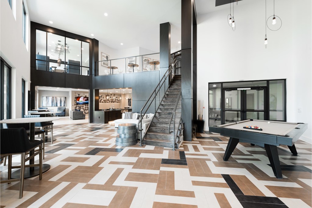a game room with a pool table and stairs
