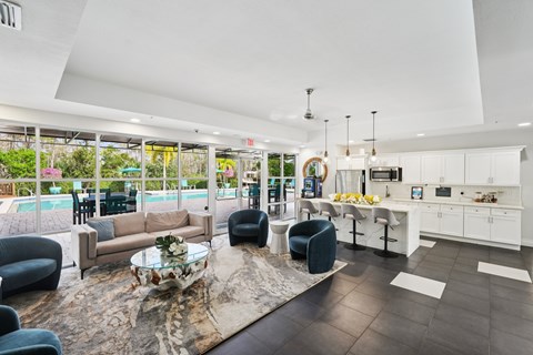 A modern living room with a pool outside the window.