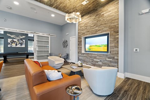A living room with a brown leather couch and a white ottoman.