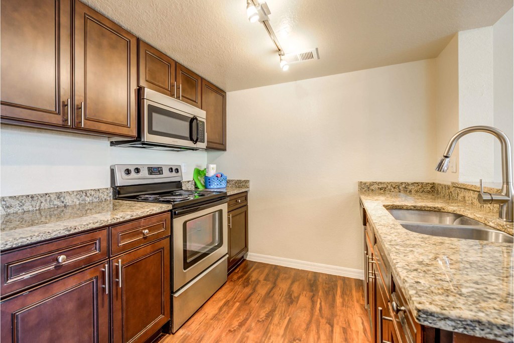 a kitchen with granite counter tops and stainless steel appliances