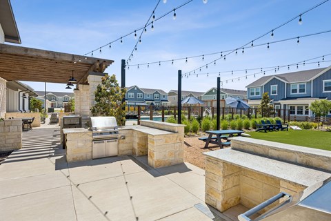 A patio with a stone wall and a hot tub.