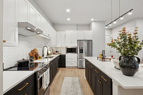 A modern kitchen with black and white cabinets and a central island.