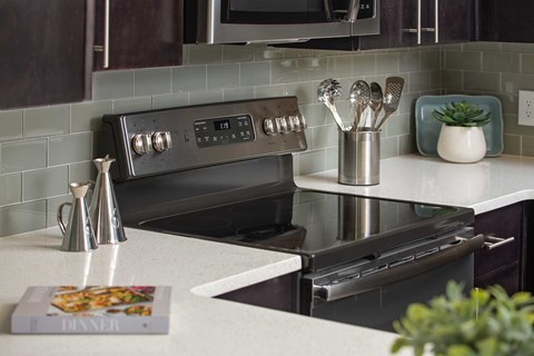 A modern kitchen with a black oven and a book on the counter.
