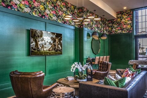 A living room with a green wall and a painting of a deer.