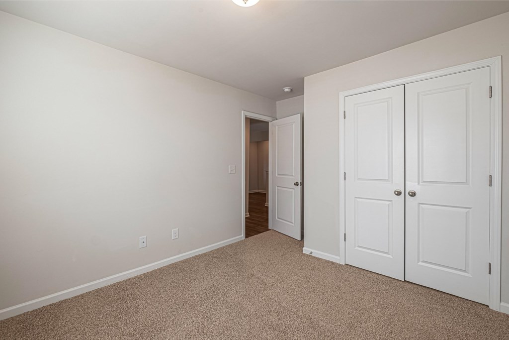 a bedroom with two closets and a door to a hallway