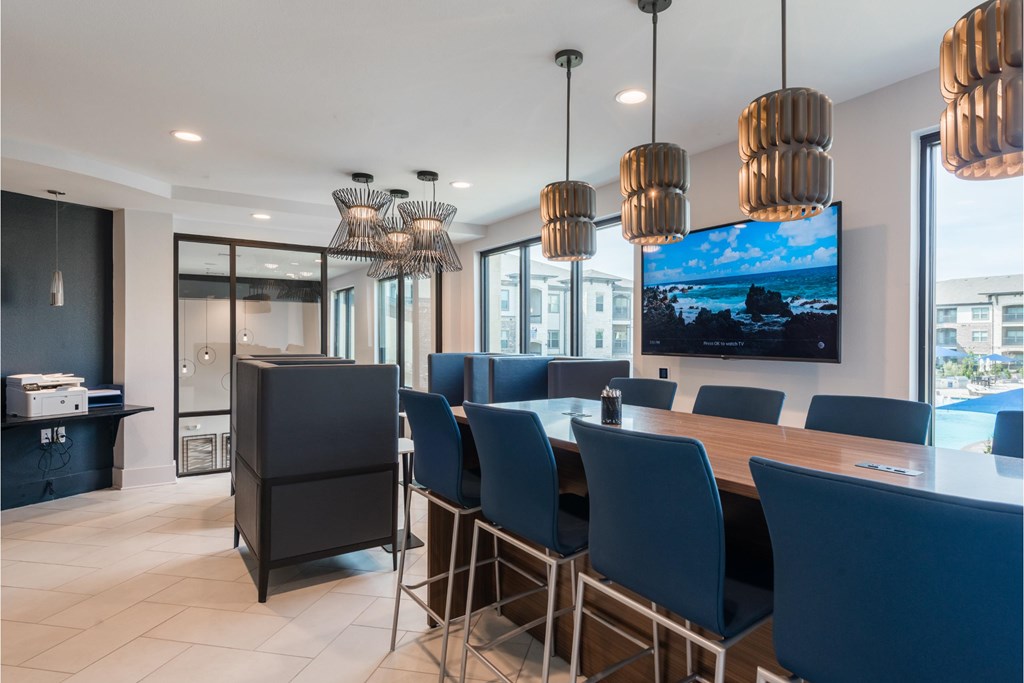 a dining room with blue chairs and a table and a tv
