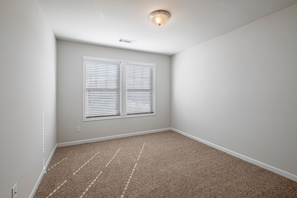 an empty room with carpet and a window