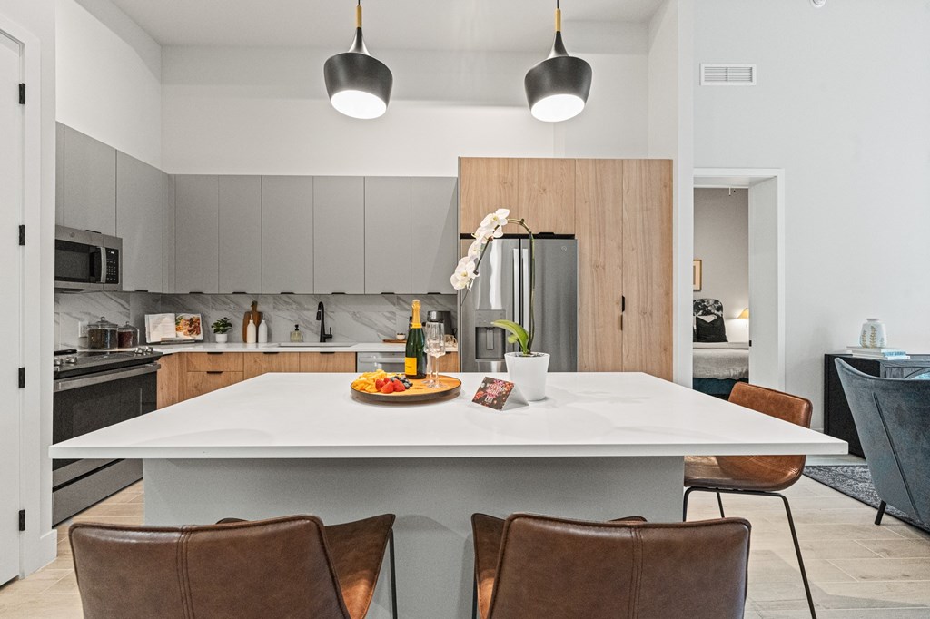 A modern kitchen with a dining table set for two.